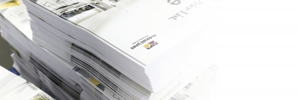 A high-angle view of stacked, custom-printed "McDonald Jones" brochures and price lists.