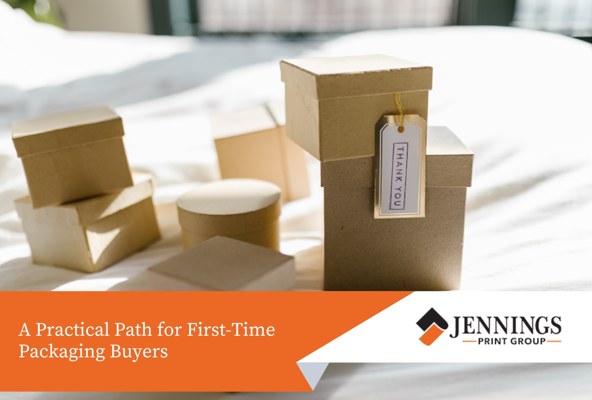 Custom Packaging: What Small Businesses Need to Know Before Their First Print Run - custom packaging A collection of small, plain kraft paper gift boxes arranged on a white fabric surface, with one box featuring a hanging "THANK YOU" tag.