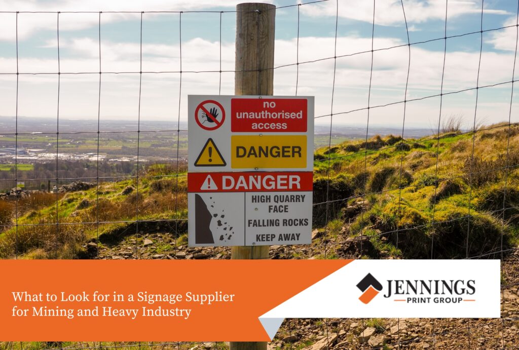 Custom Safety Signs for Mining and Heavy Industry: What Makes a Sign Fit for Purpose - Sign Industrial quarry danger sign mounted on a fence post at a heavy mining site.